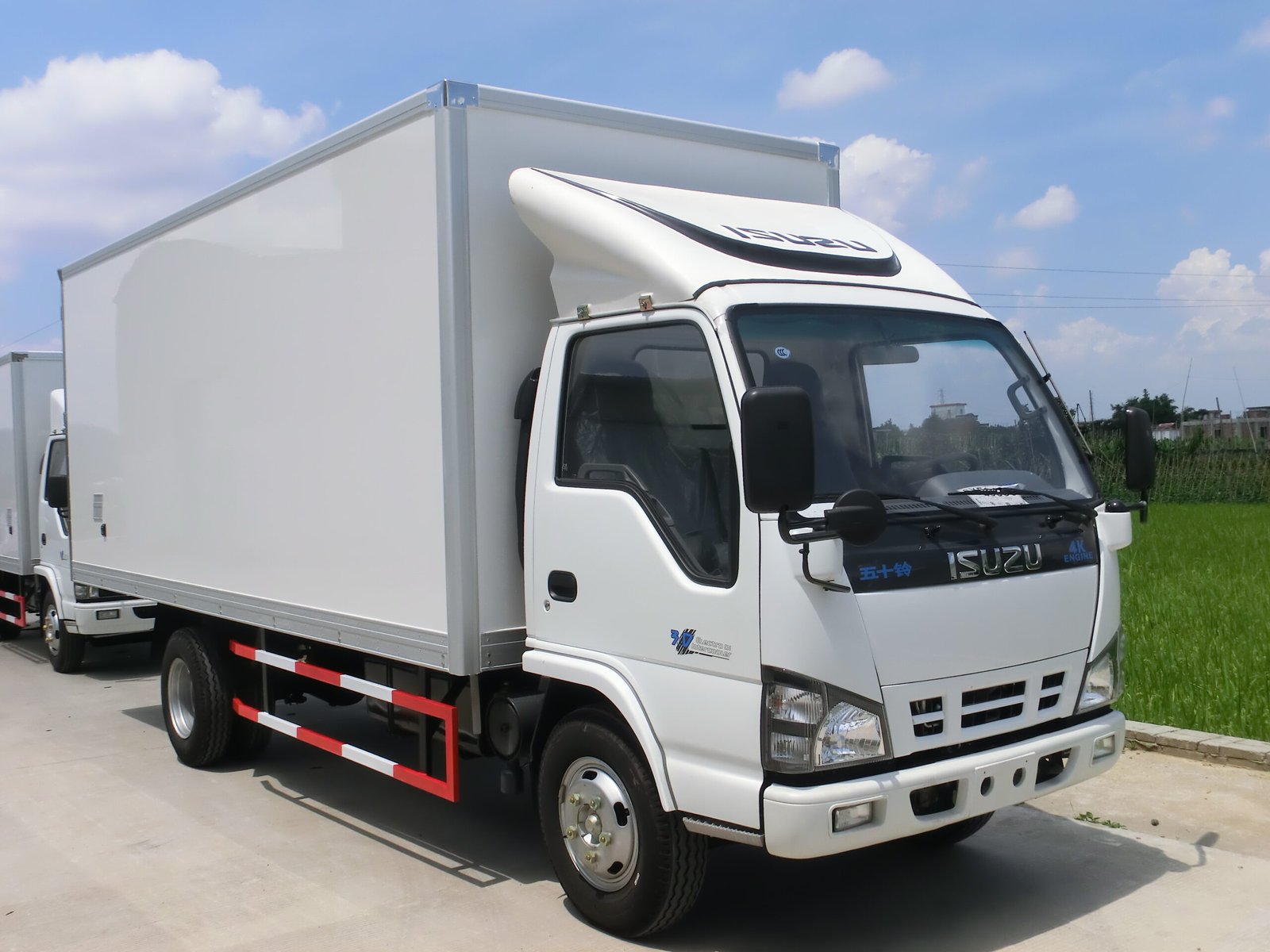 Insulated truck body mounted on an Isuzu chassis, viewed from the front side