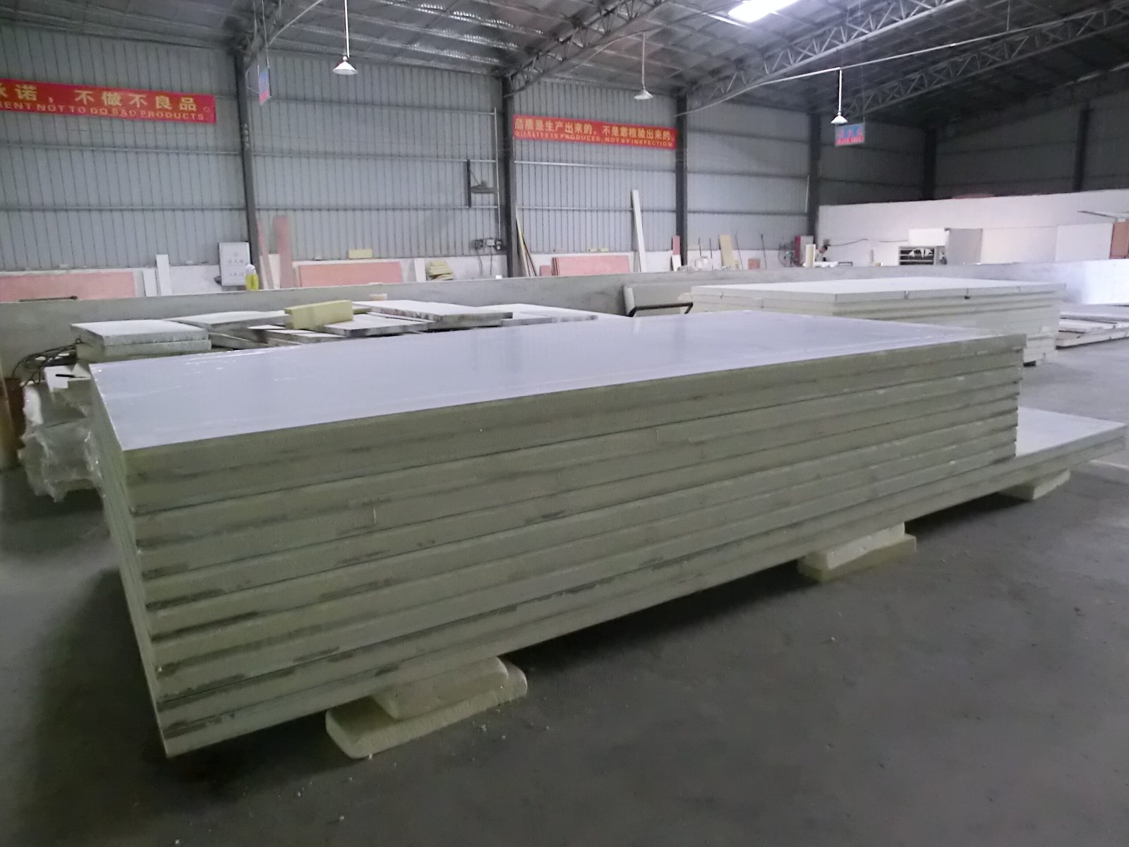 Insulated panels stacked horizontally in a workshop