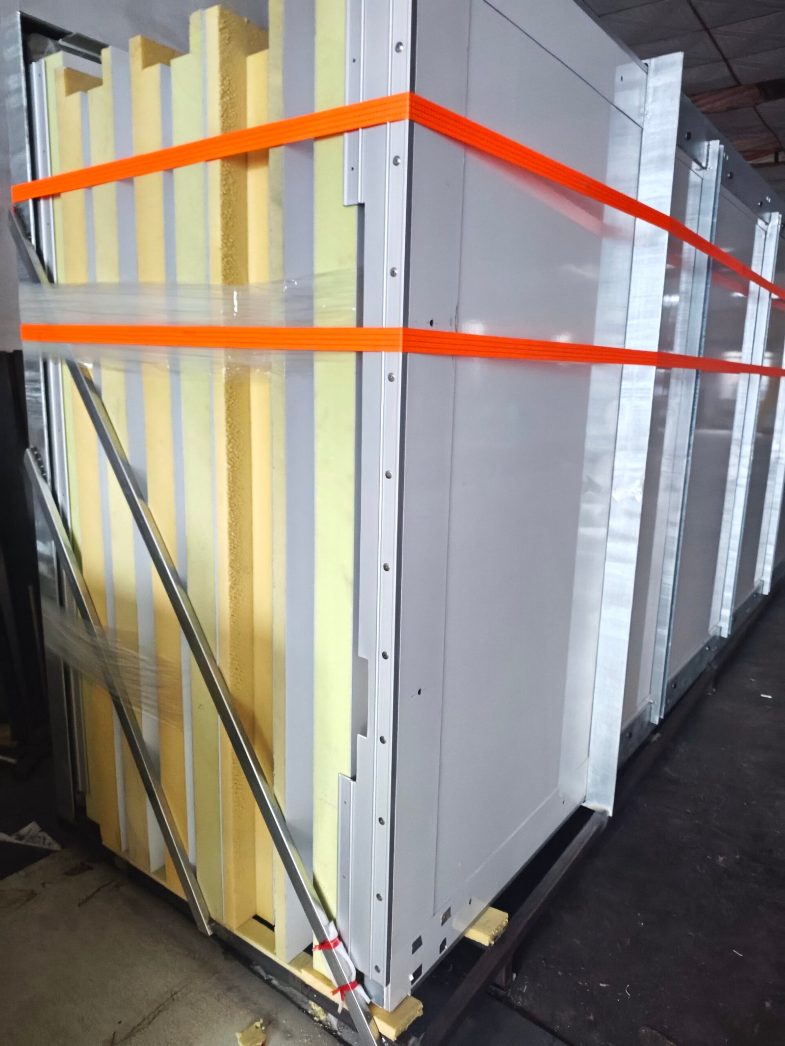 Upright insulated body panels secured with orange straps for packing