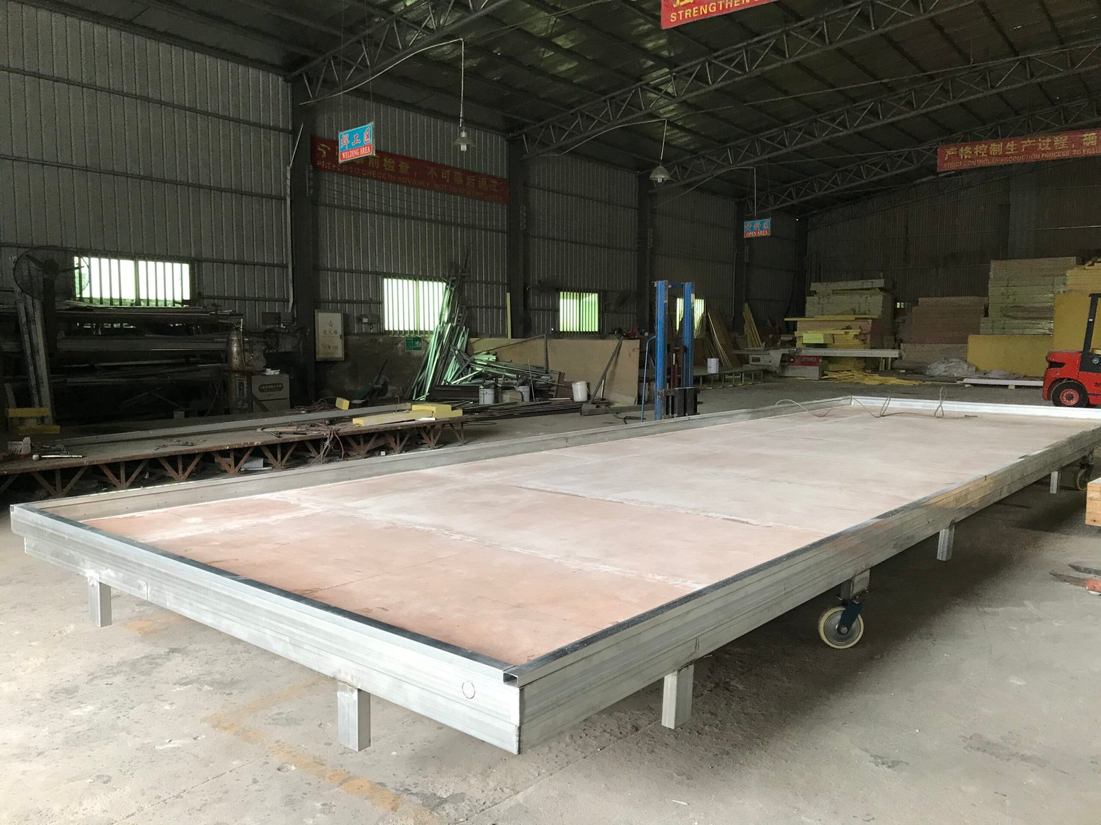 Large framed panel assembly on supports in a workshop.